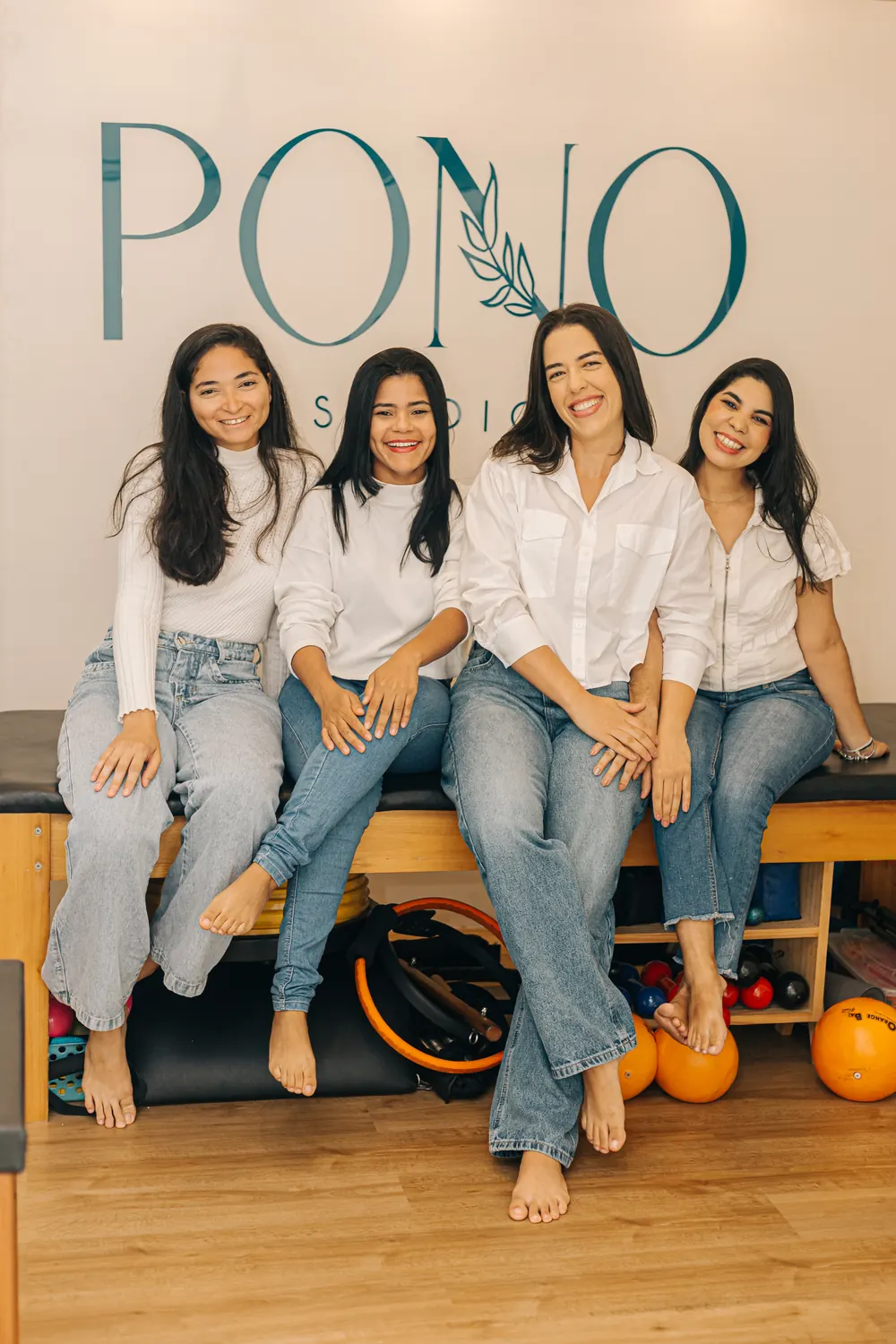 Equipe profissional da PONO Studio em frente à marca